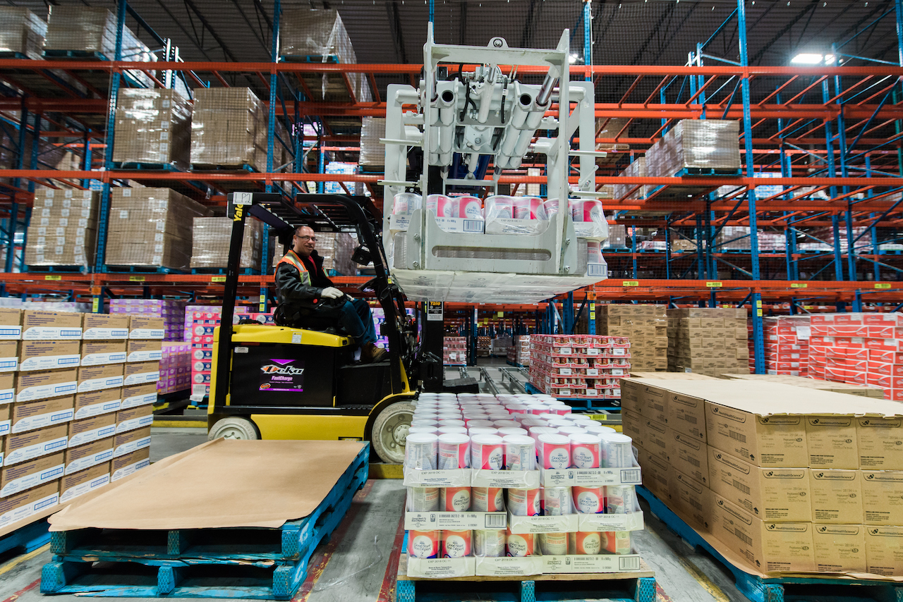 Operator driving forklift through a warehouse.